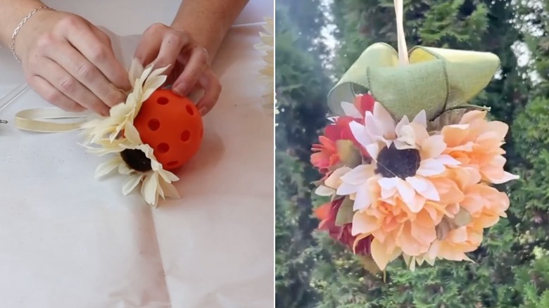 Hands attach artificial flowers to an orange Wiffle Ball and a floral ball wreath for fall hanging in a garden.