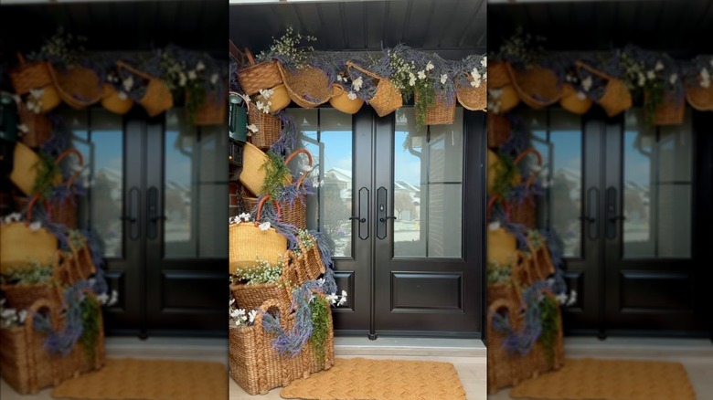 An entryway that's partially framed with baskets of various sizes and colors, filled with dried lavender, white flowers, and greenery.