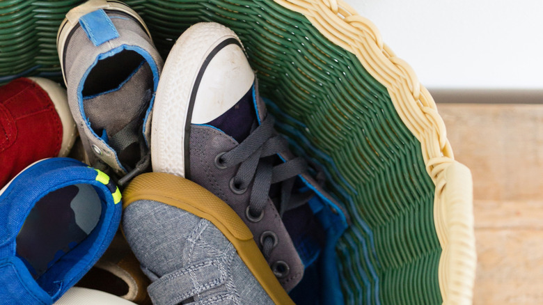 Several pairs of shoes in green basket
