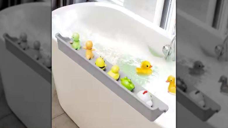 The Anqtovp splash guard on a white bathtub with kids bath toys sitting on it.