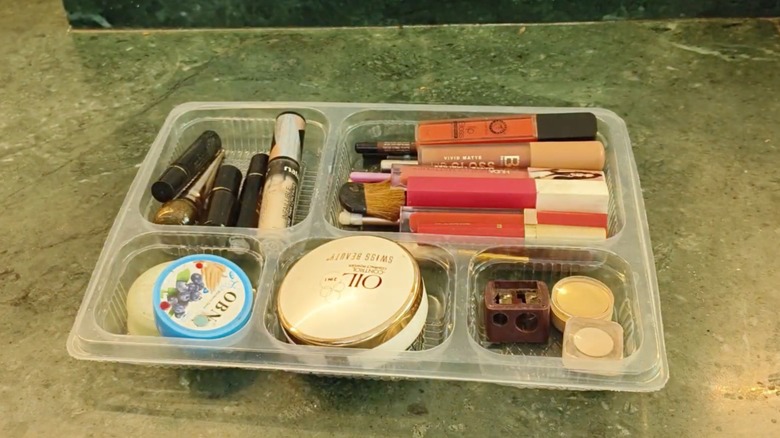 Takeout container lid turned into a makeup drawer organizer.