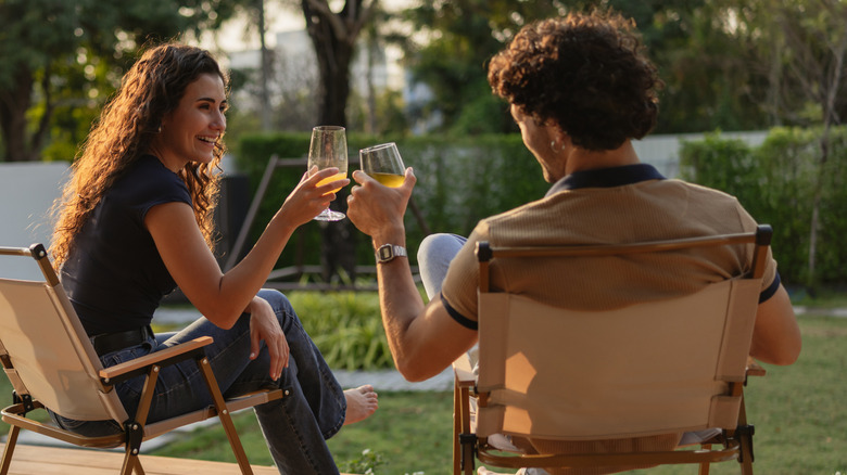 a couple drinking wine on a patio at sunset