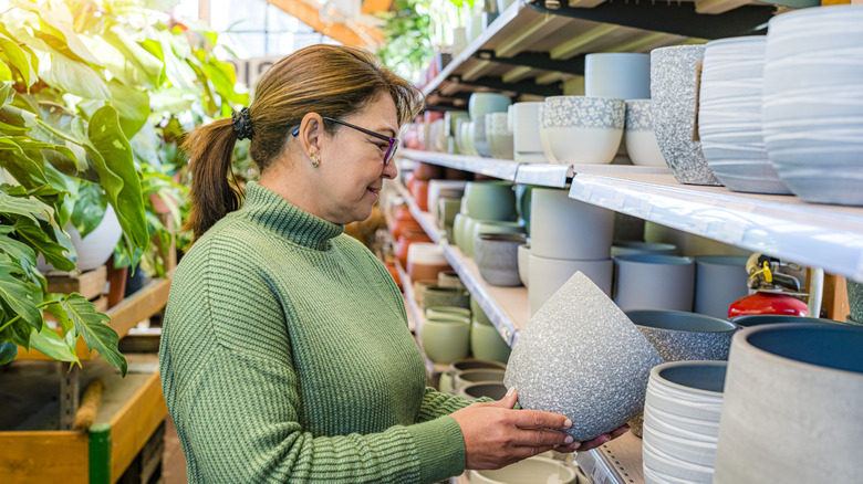 A woman shopping for ceramic pots at a garden store