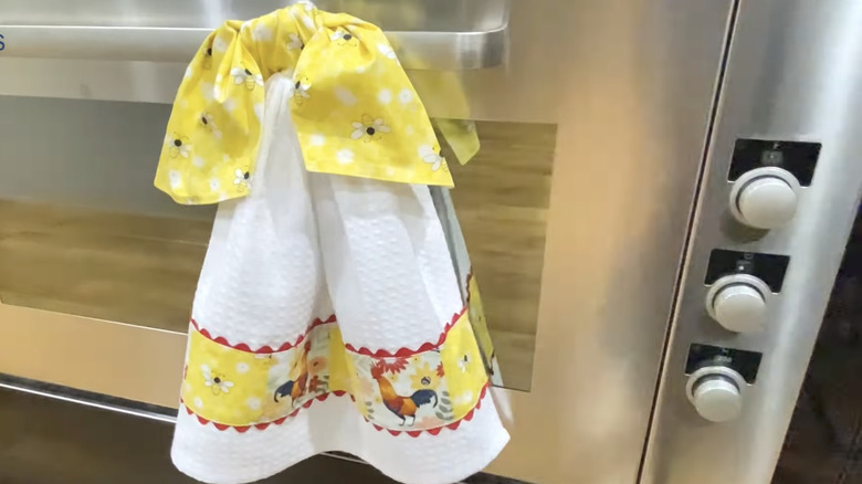 A tea towel with a DIY tie hangs on the oven door.