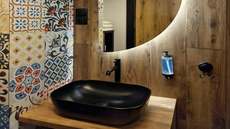 Backlit half-moon bathroom mirror