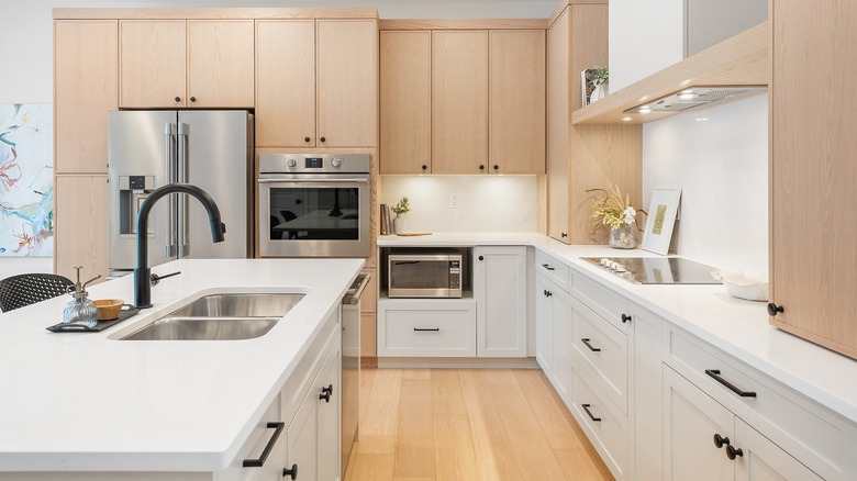 A modern kitchen with light-color wood upper cabinets