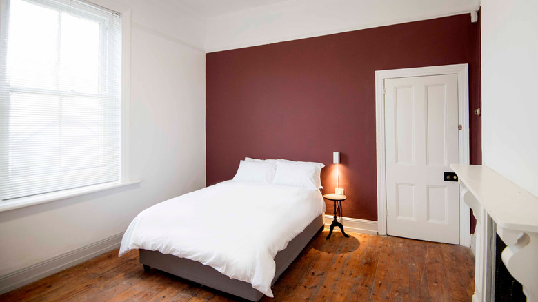 A bare bedroom with a maroon accent wall