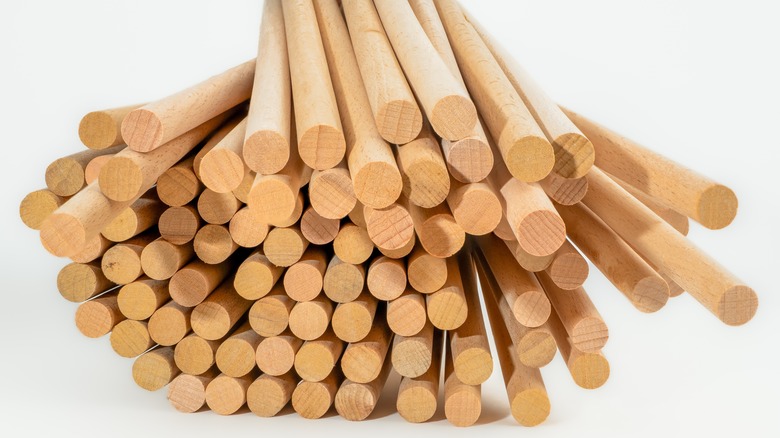Pile wood dowel rods on white background
