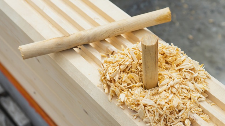 wood dowel stuck in house wall timber with shavings surrounding it