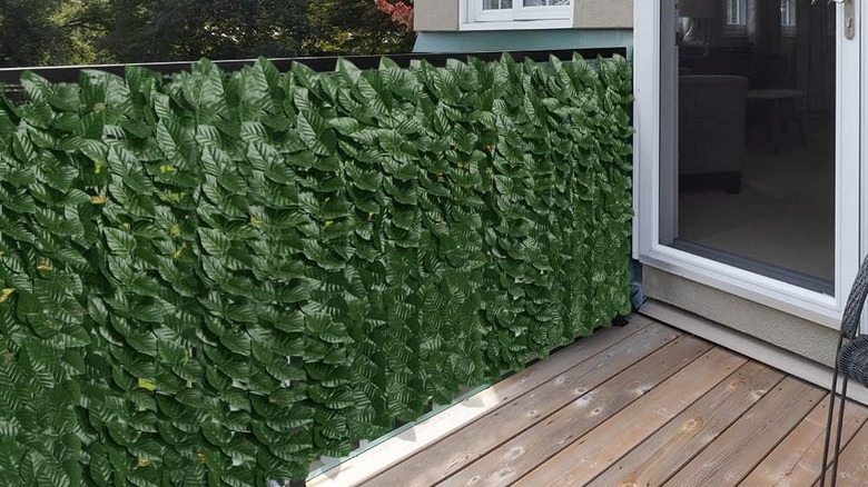 The artificial ivy mat from iCover hung up on a patio to block the view