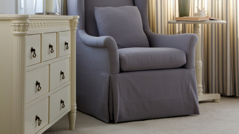Purple skirted chair with white dresser and table