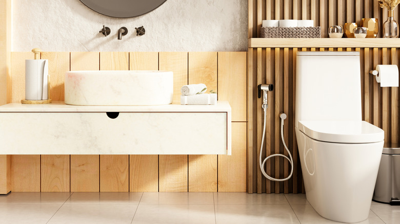 Skirted toilet in a modern bathroom with wood paneled walls and sleek design