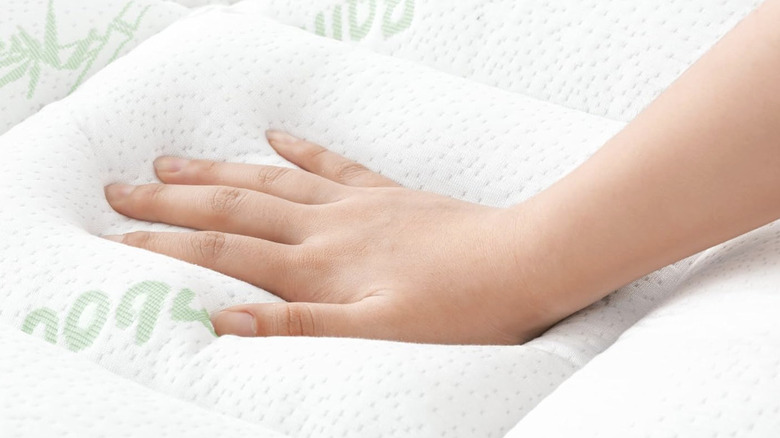 White Niagara Sleep Solutions mattress topper with a hand pressing down on the top