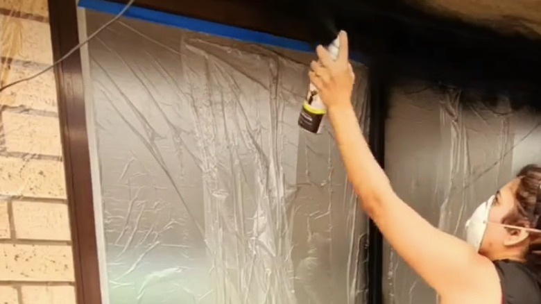 DIYer spraypaints sliding window in project