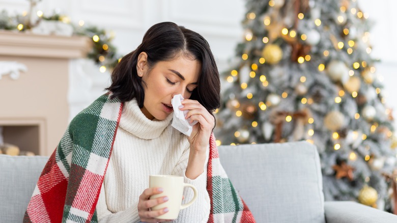 woman with allergy symptoms near christmas tree