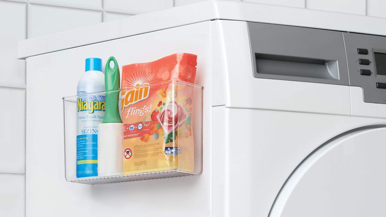A plastic storage bin on the side of a washing machine