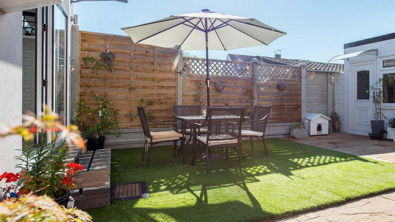 Umbrella shading chair and table on imitation grass