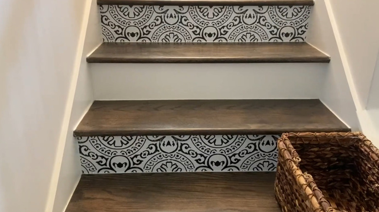 A staircase with a wallpapered riser every other step.