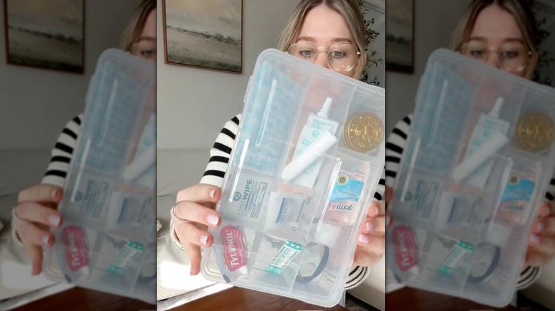 Woman holding up a first aid kit made with a Dollar Tree compartment case.