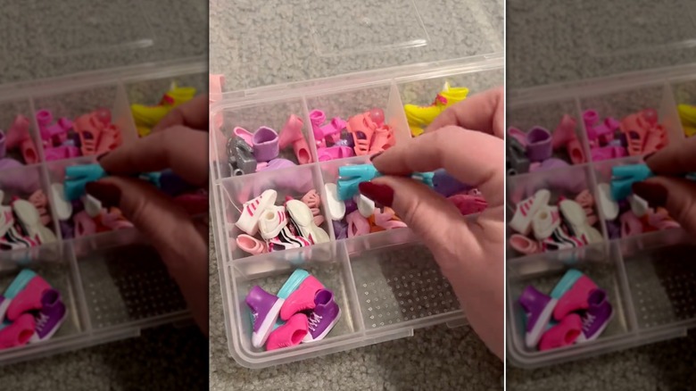 Woman's hand placing barbie doll shoes in plastic compartment case for storage.