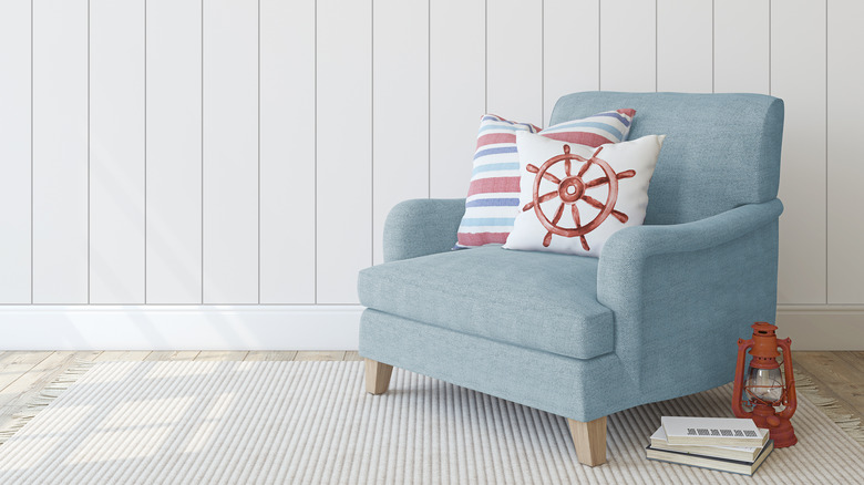 Blue chair against paneled wall with coastal pillows