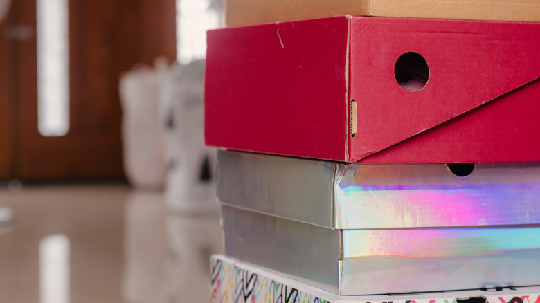 A stack of multicolored shoe boxes are set in someone's living room.