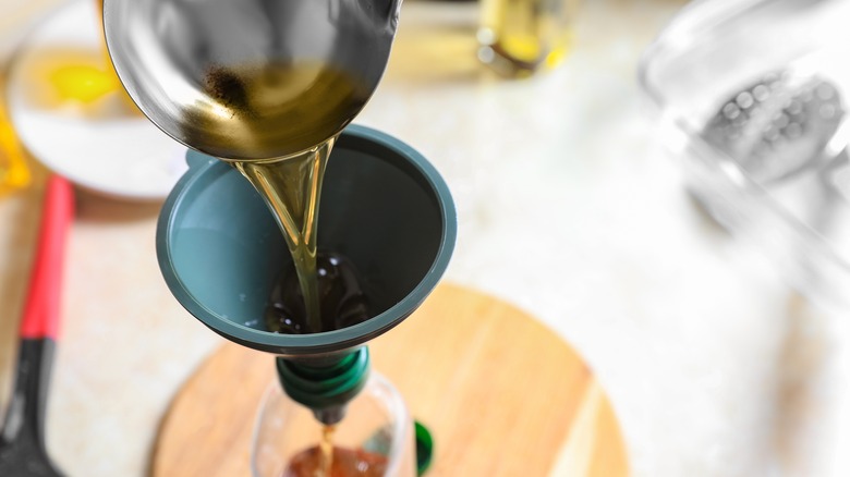 person using funnel in bottle