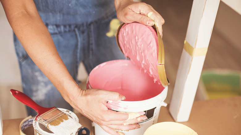 person opening can of paint