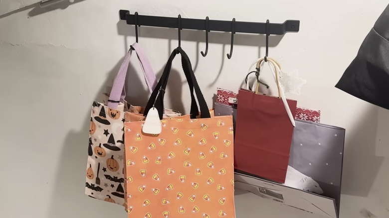 Rail storage used in basement stairway to hang extra bags.