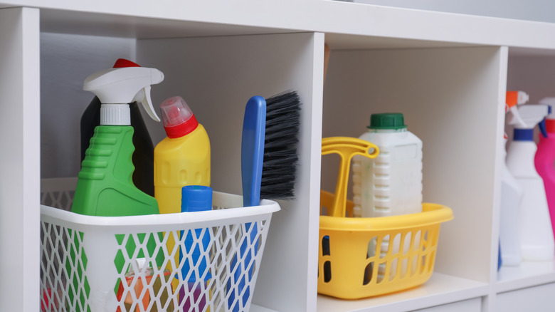 baskets of cleaning supplies in storage cubbies