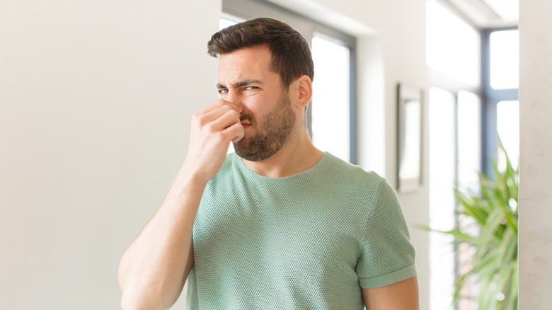 man holding his nose