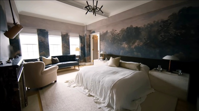 A master bedroom with forest wallpaper.
