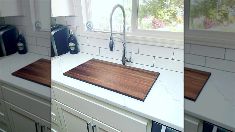 A kitchen sink covered with a wooden cover