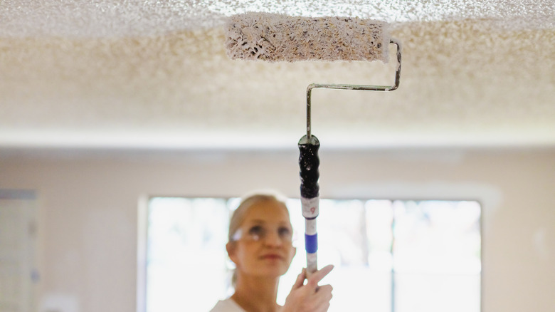 woman painting a textured ceiling