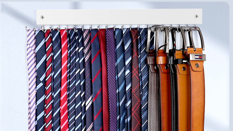 The Wall Mounted Tie Rack by Oteckk up close, full of belts and colorful ties