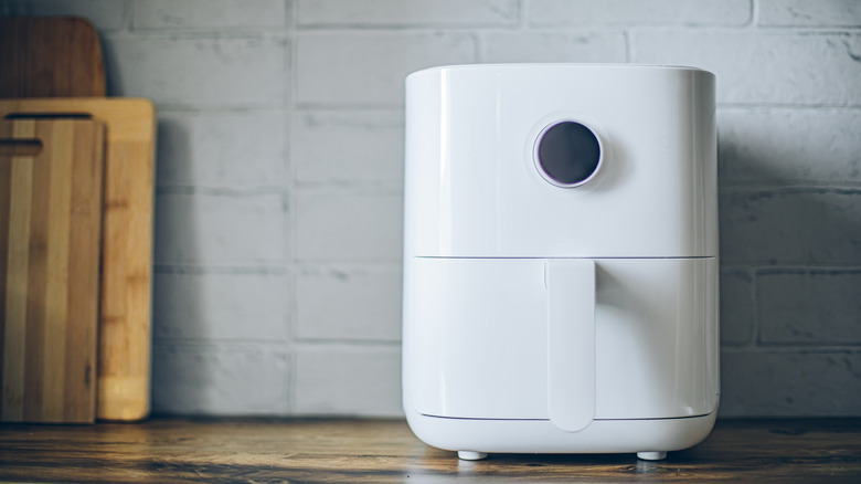 air fryer sitting on counter beside cutting boards