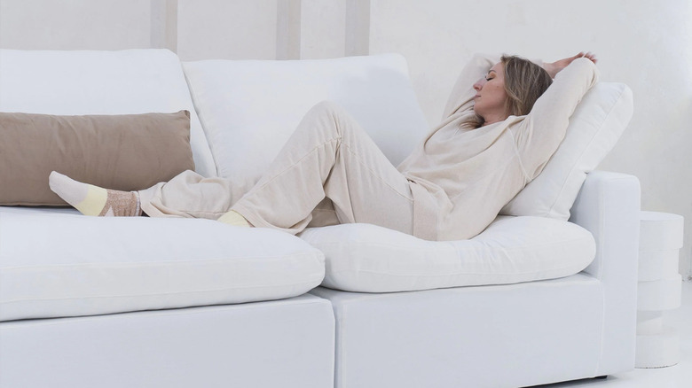 Woman reclining on white Sofatica