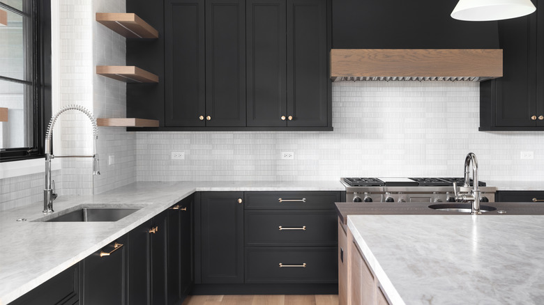 Kitchen with chic black cabinets and modern white tiling