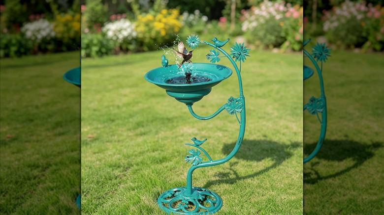 HOUYANG's 25.8-inch Solar Metal Bird Bath in a garden, with splashing bird