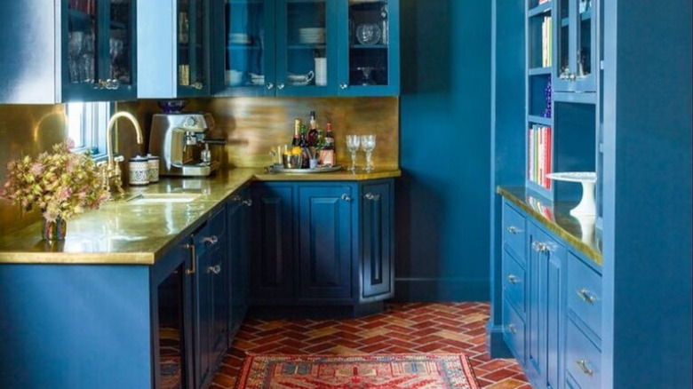 A blue cozy kitchen with brass countertops