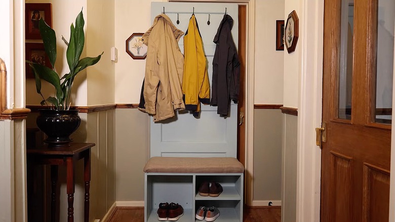 Repurposed door made into a hall tree with hooks and storage