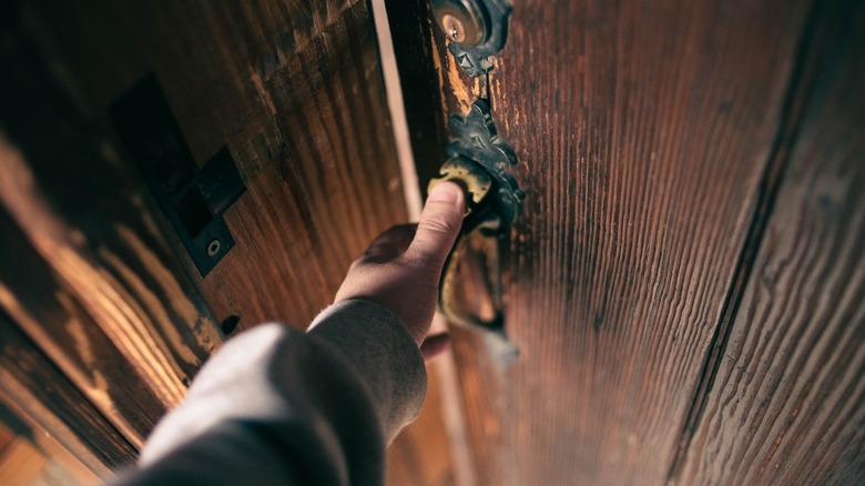 Person closing old door