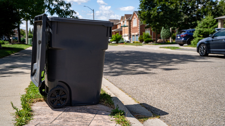 Outdoor garbage can on sidewalk.