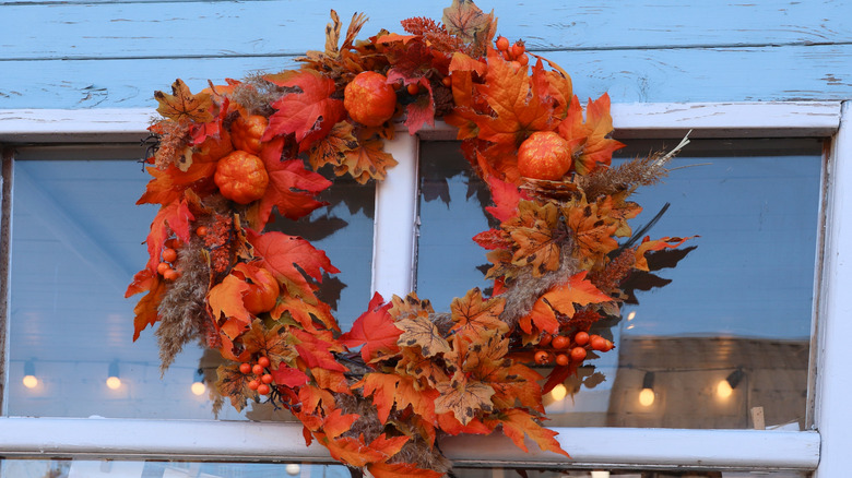 A fall-themed wreath decorated with tiny pumpkins