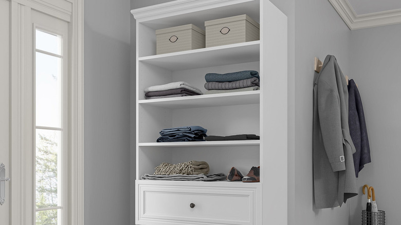 Upper portion of the Bestar Audrea storage unit with folded clothes on the open shelves and drawers below