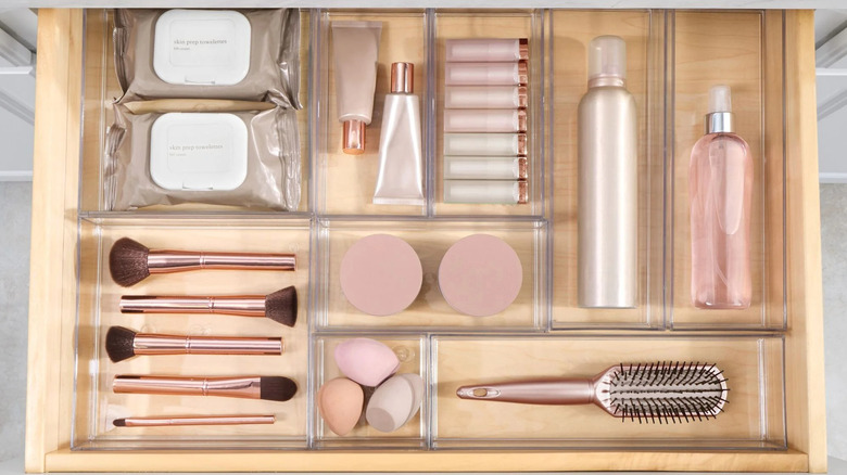iDesign drawer organizer set with various accessories and beauty products in the compartments
