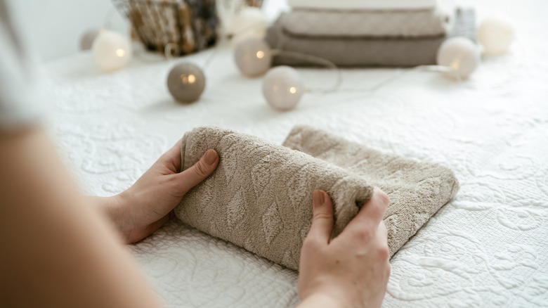 A person neatly folding a towel