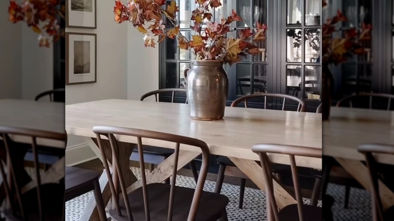 A set of dark wood spindle back chairs is arranged in a well designed dining room