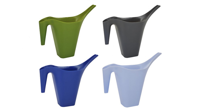 Four different colored watering cans against a white background