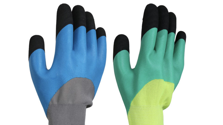 Blue and green safety gloves against a white background